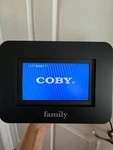 Coby 7" Widescreen Digital Photo Frame W/ Manual, Remote, 2 Extra Frsmes. Fixed Price $28.64.